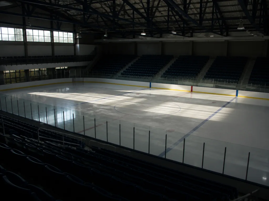Tom ishockeyarena med blank is och läktare inför en kvalmatch