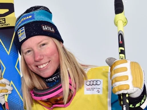 Sandra Näslund i gul tävlingsväst och mössa med svenska flaggan efter en världscuptävling i skicross