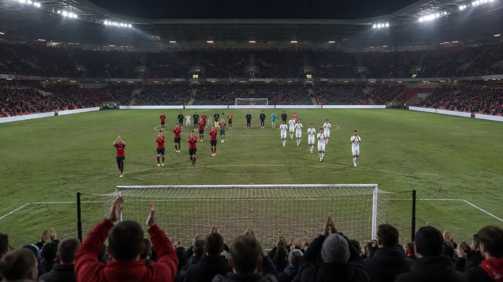Spelare applåderar publiken efter matchen i kvällsljus